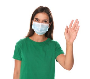 Woman in protective mask showing hello gesture on white background. Keeping social distance during coronavirus pandemic