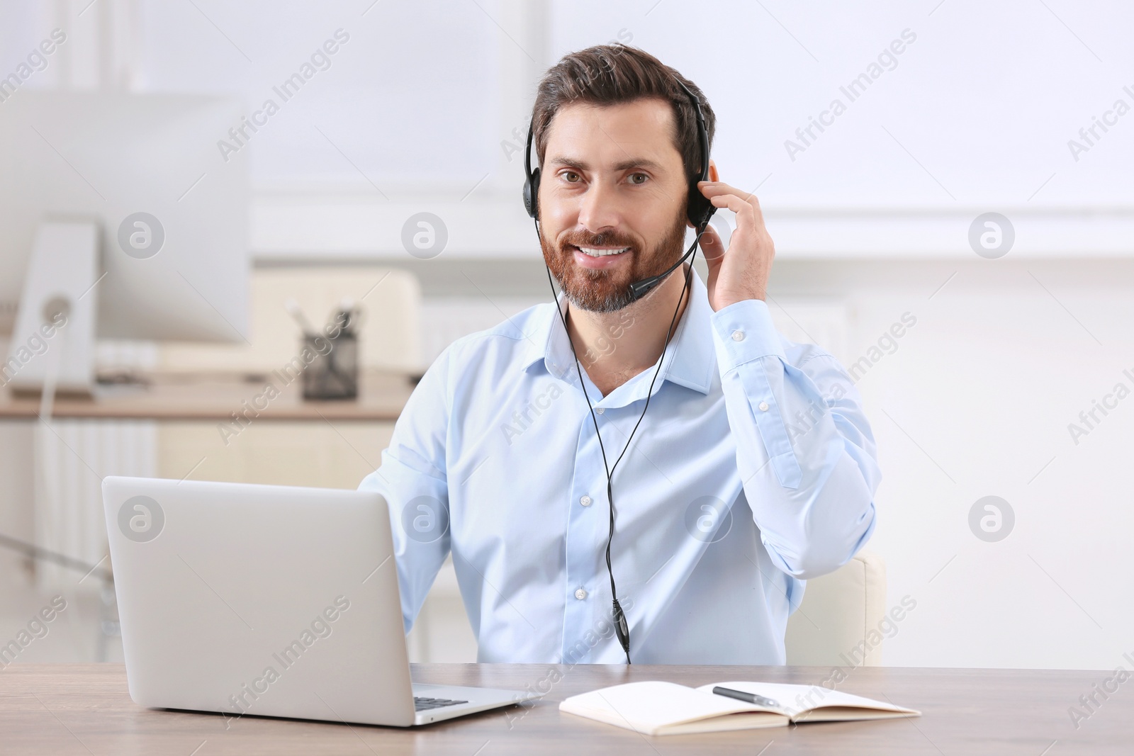 Photo of Hotline operator with headset working in office