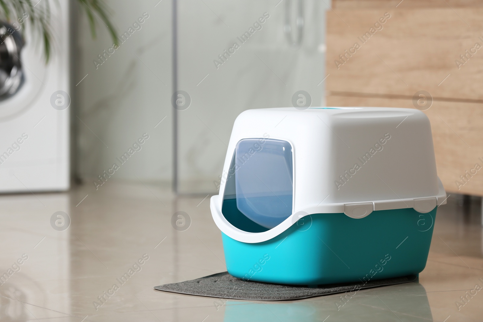 Photo of Cat litter box on floor in bathroom. Space for text