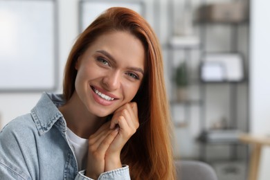 Photo of Portrait of beautiful young woman with red hair at home. Attractive lady smiling and looking into camera. Space for text