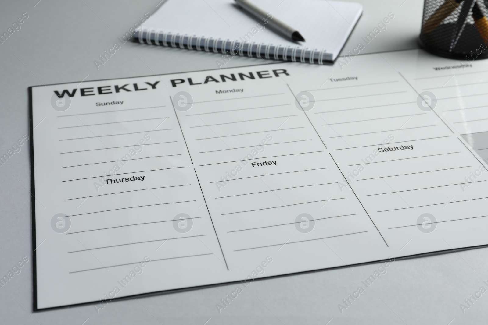 Photo of Timetable. Planner, notebook and pen on grey table, closeup