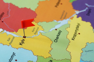 Photo of Map of Ukraine with red flag push pin placed on Kyiv, closeup