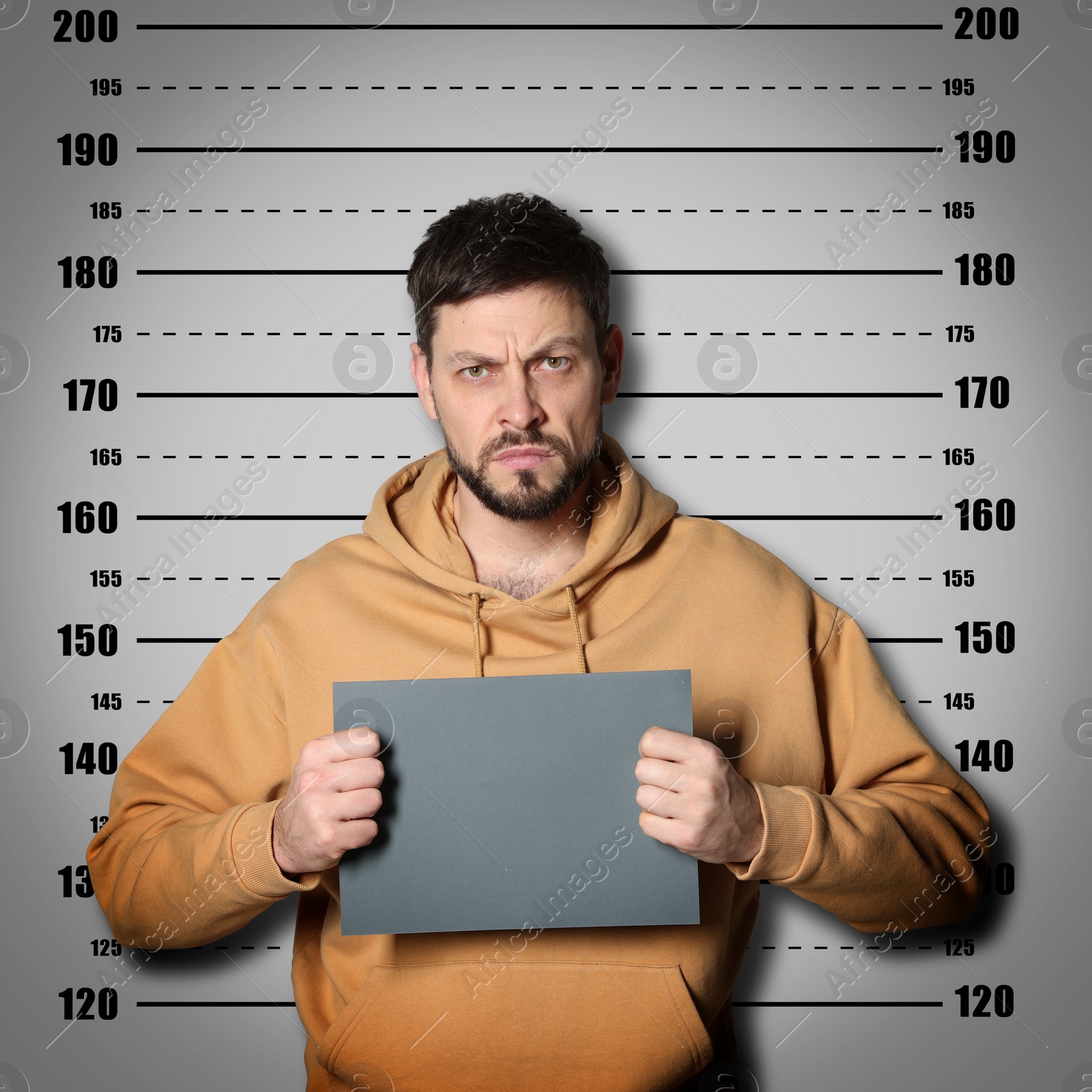 Image of Criminal mugshot. Arrested man with blank card against height chart