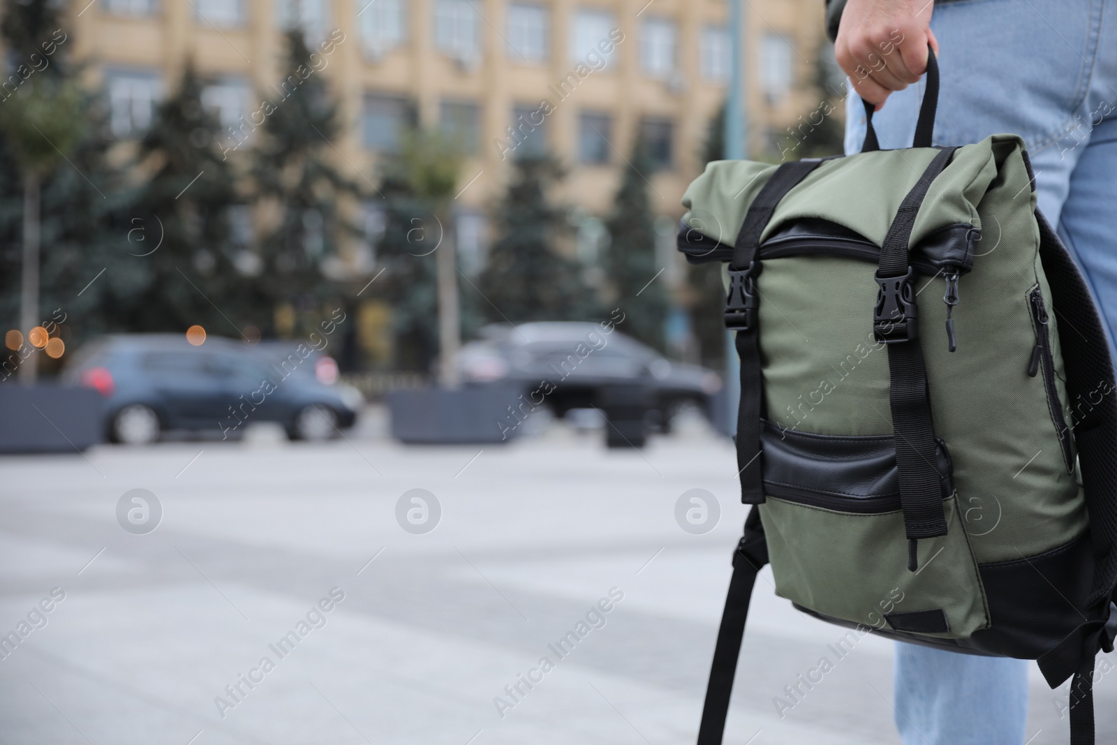 Photo of Male tourist with travel backpack on city street, closeup. Urban trip