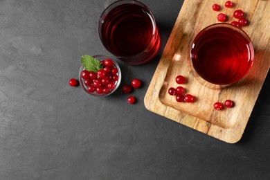Photo of Tasty refreshing cranberry juice and fresh berries on grey textured table, flat lay. Space for text