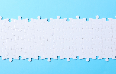 Photo of Blank white puzzle light blue background, top view