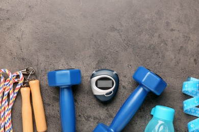 Photo of Flat lay composition with dumbbells on brown textured table, space for text