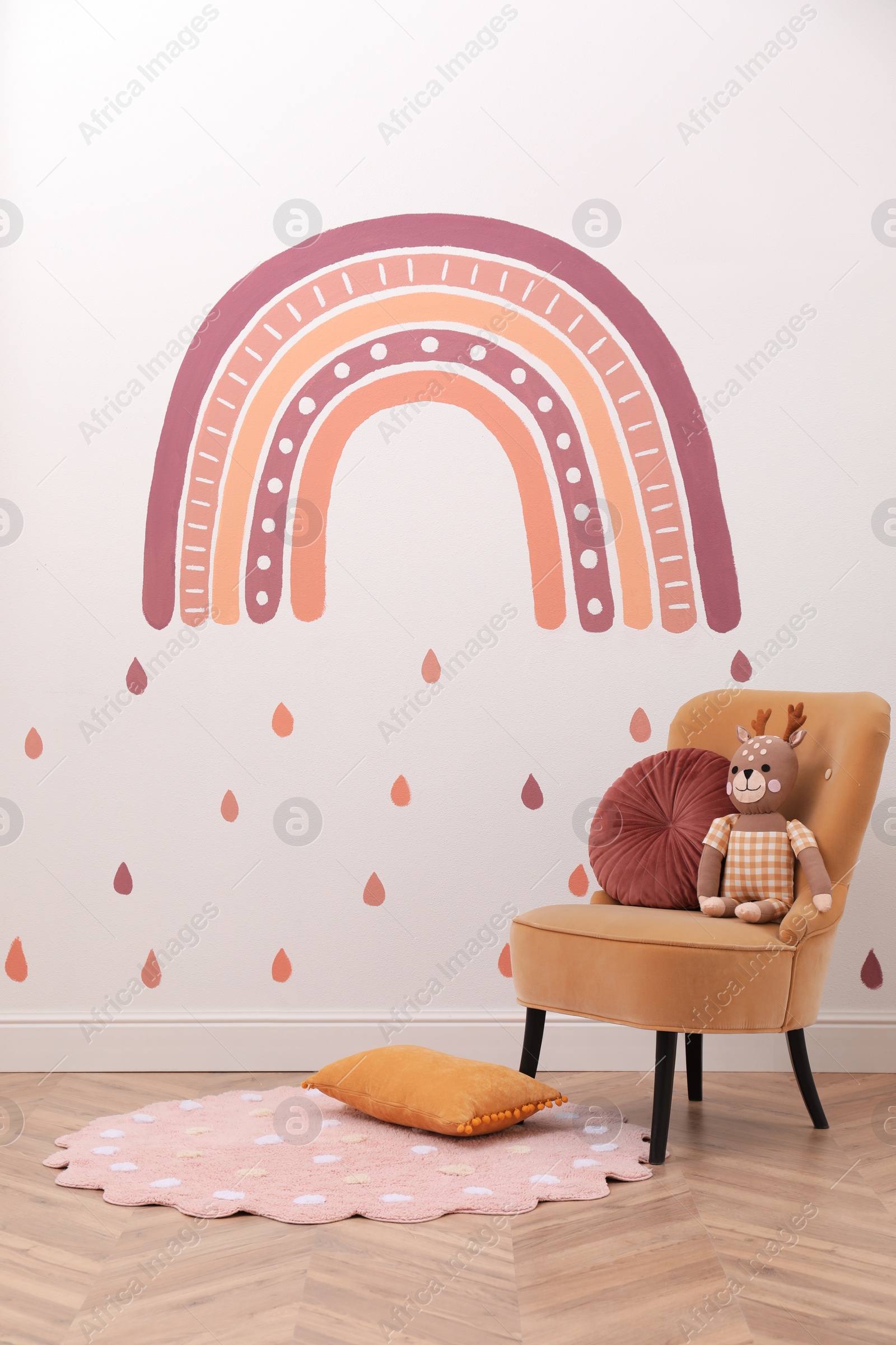 Photo of Child's room interior with comfortable armchair, toy and painting on white wall. Stylish design