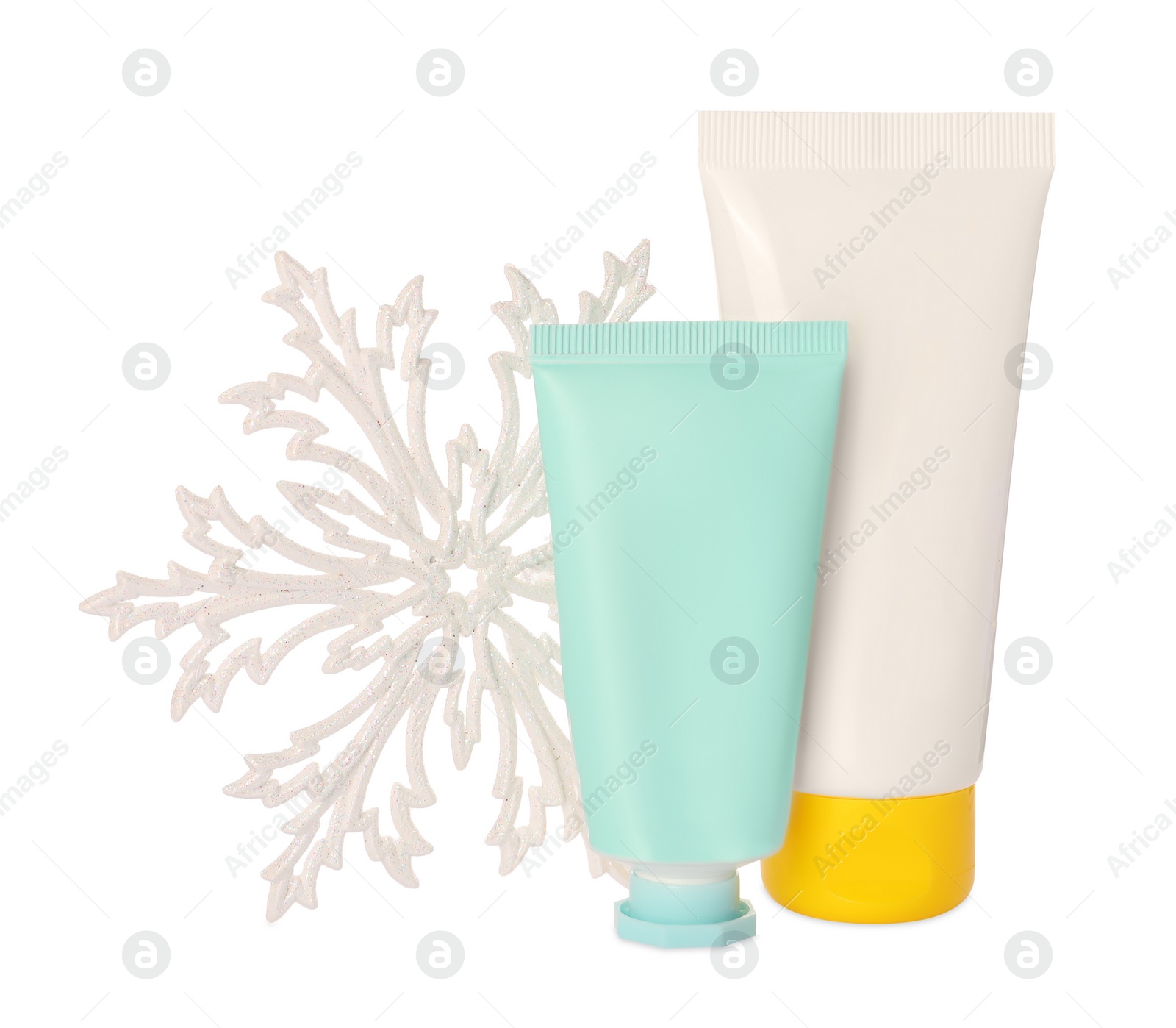 Photo of Tubes of hand cream and snowflake isolated on white. Winter skin care