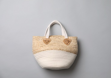 Stylish straw bag on grey background, top view. Summer accessory