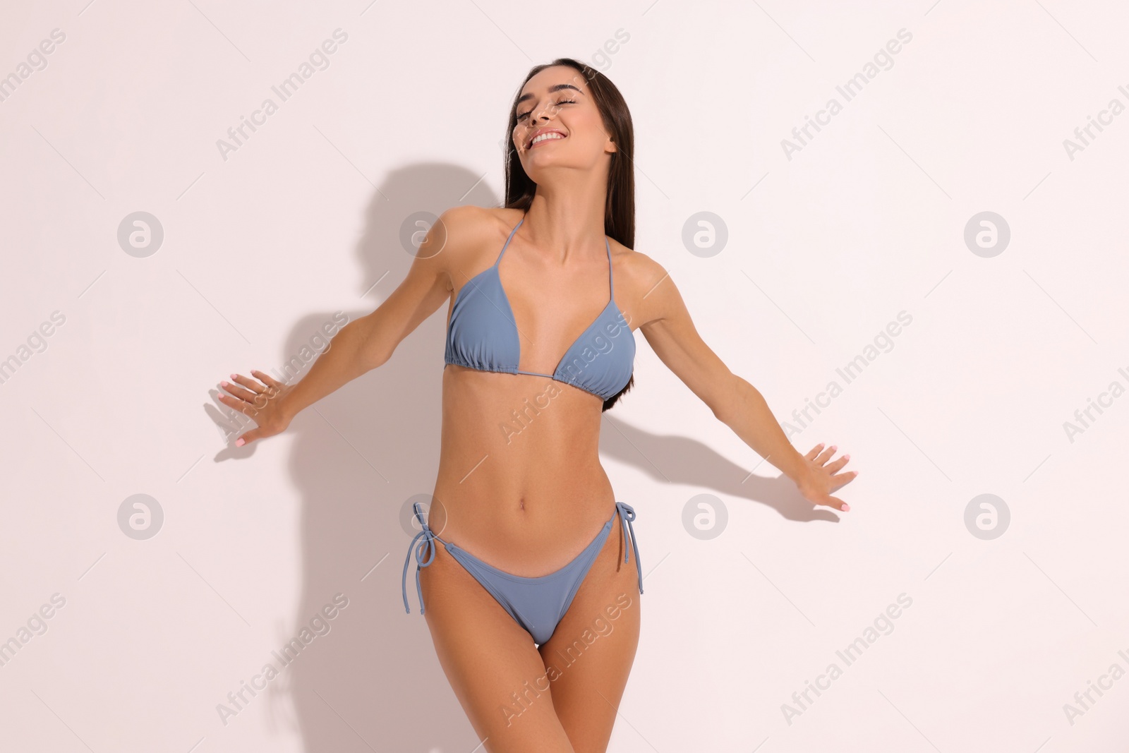 Photo of Young woman in stylish bikini on white background