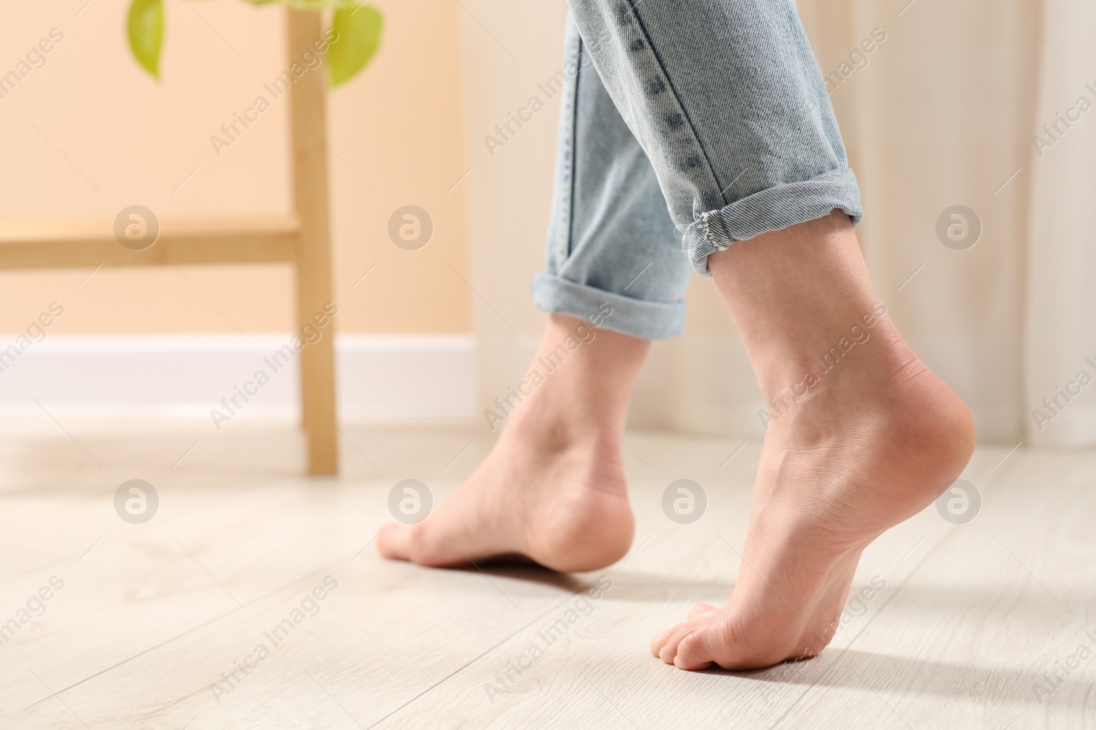 Photo of Woman stepping barefoot in room at home, closeup. Floor heating