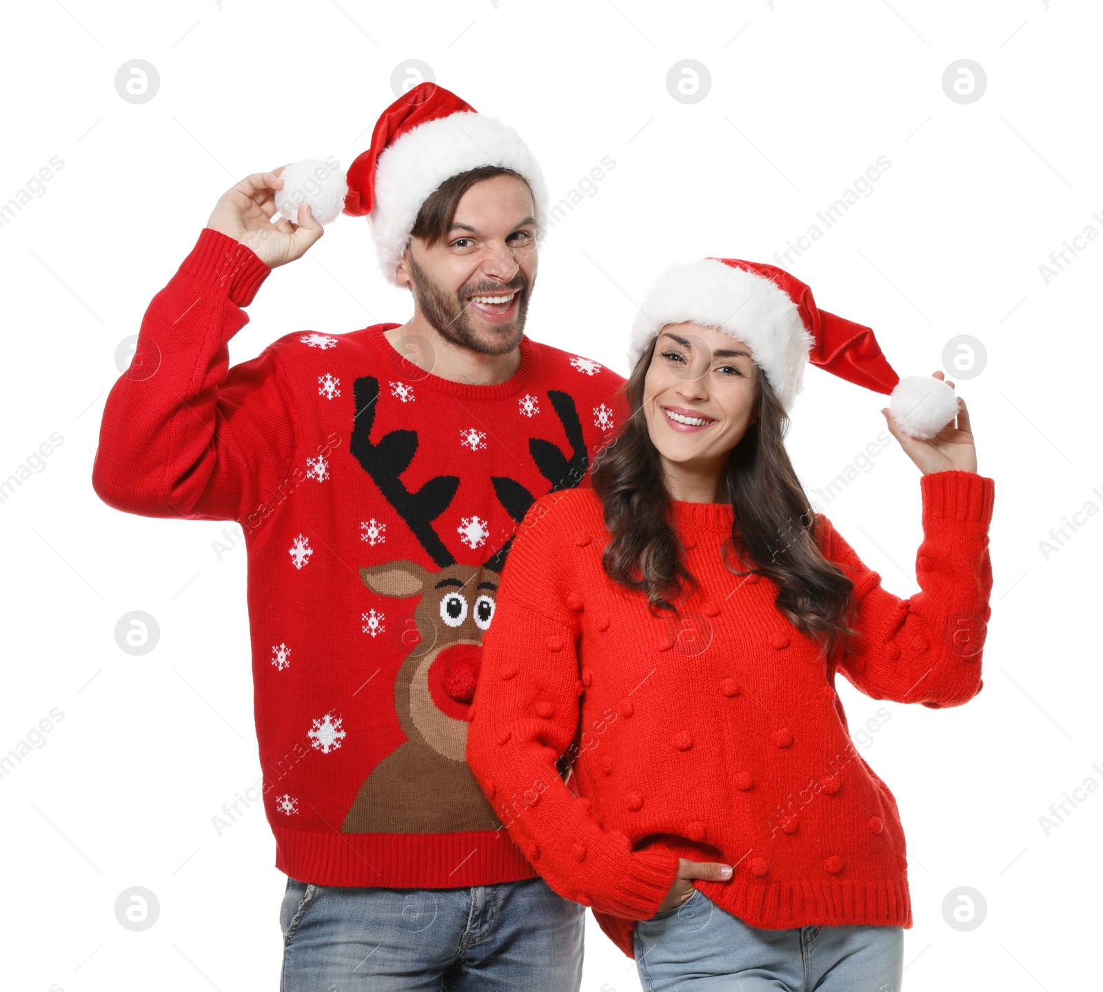 Photo of Young couple in Christmas sweaters and hats on white background