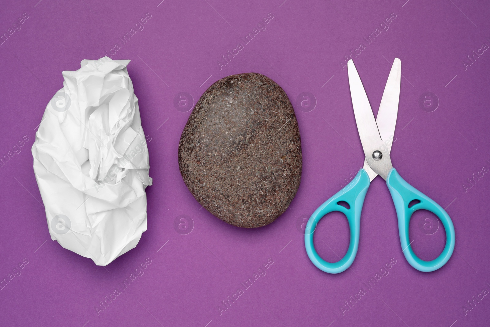 Photo of Rock, crumpled paper and scissors on purple background, flat lay