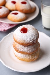 Photo of Hanukkah donuts with jelly and powdered sugar on light grey table