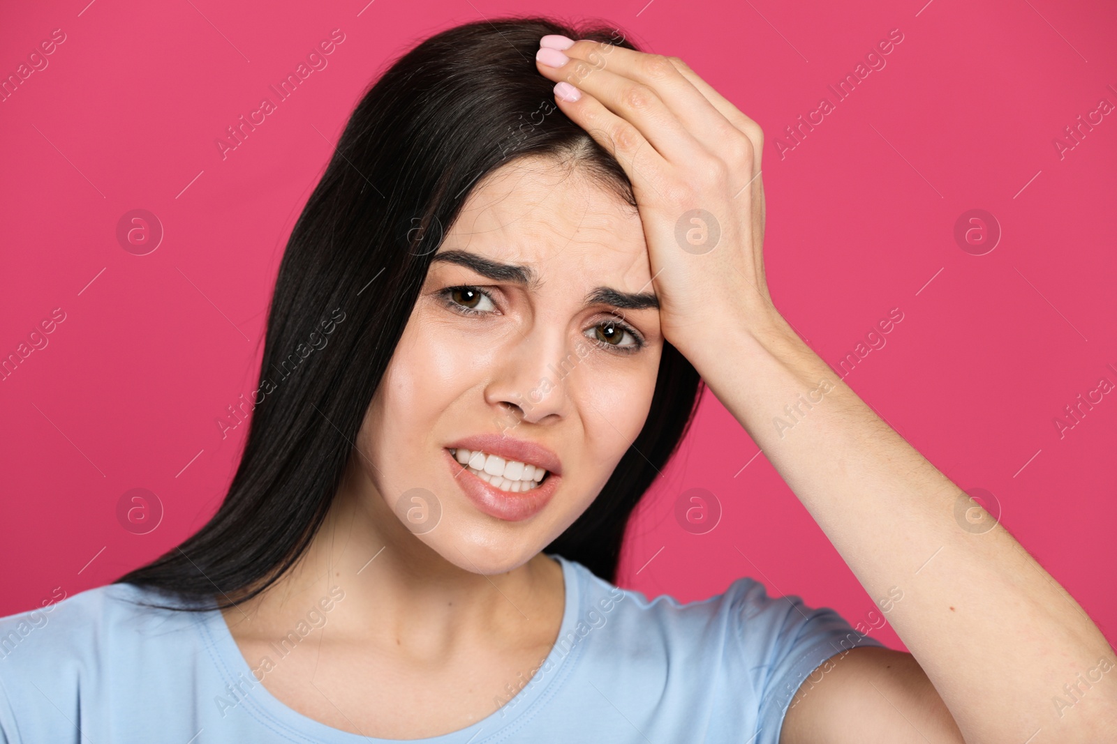 Photo of Woman suffering from migraine on pink background