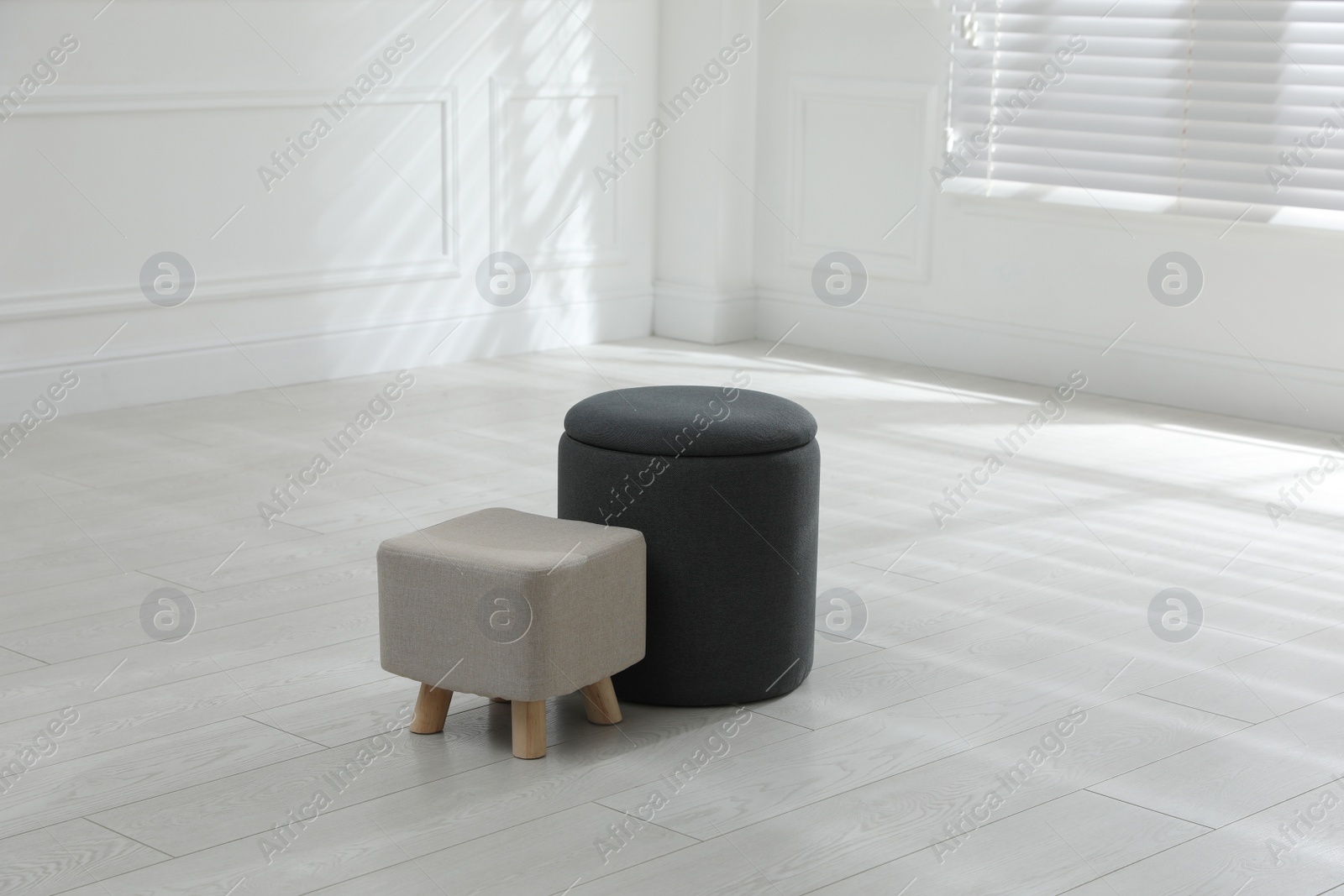 Photo of Different stylish ottomans in room. Home design