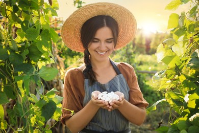 Photo of Woman holding white beans in hands outdoors