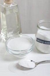Photo of Baking soda and vinegar on white wooden table