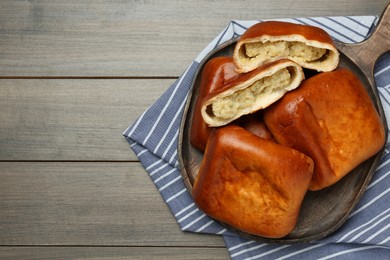 Photo of Delicious baked patties with potato on wooden table, top view. Space for text