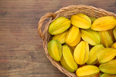 Delicious ripe carambolas in wicker basket on wooden table