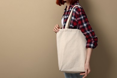 Photo of Woman with eco bag on beige background, closeup. Space for text