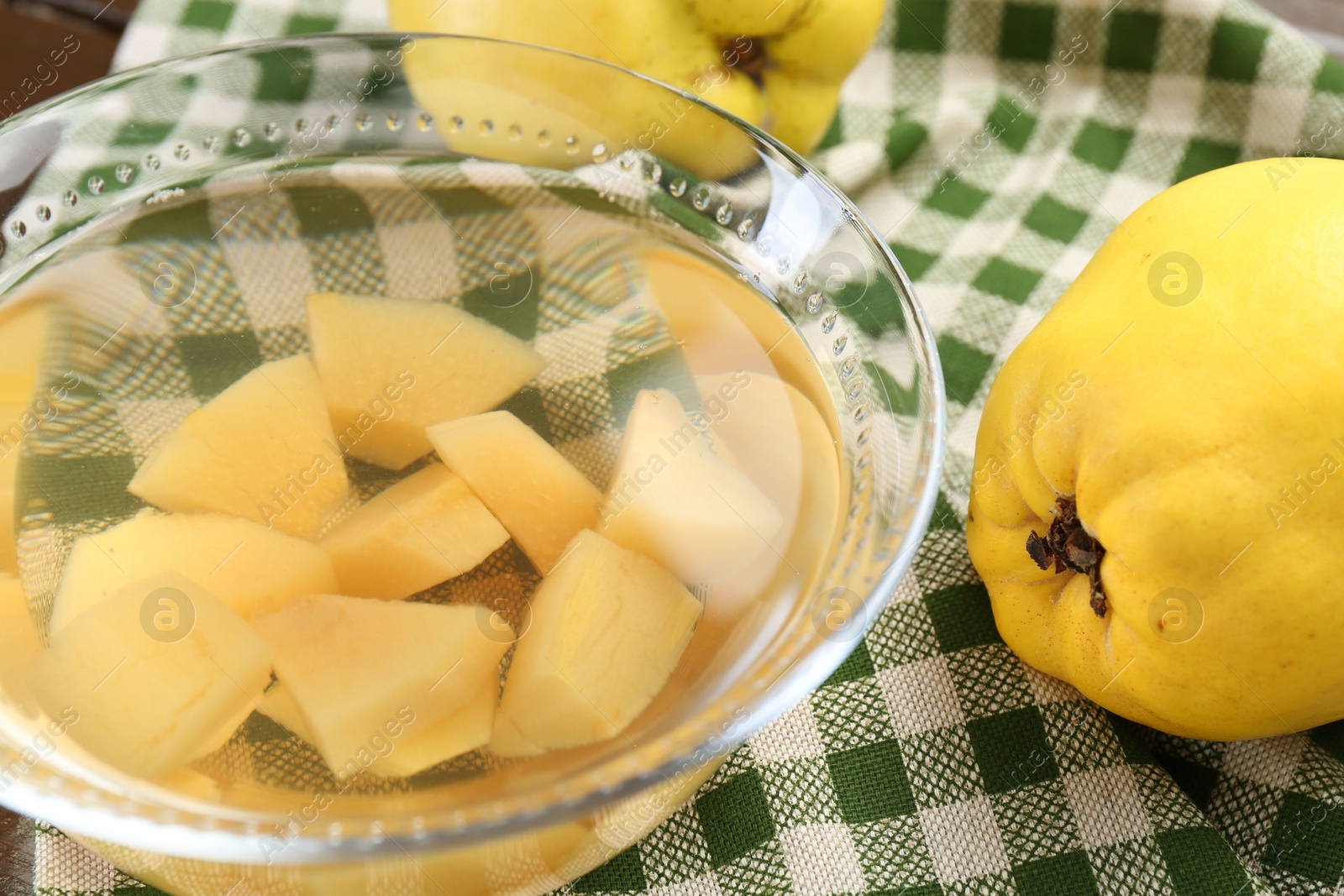 Photo of Delicious quince drink in glass bowl and fresh fruits on table, closeup