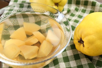 Delicious quince drink in glass bowl and fresh fruits on table, closeup