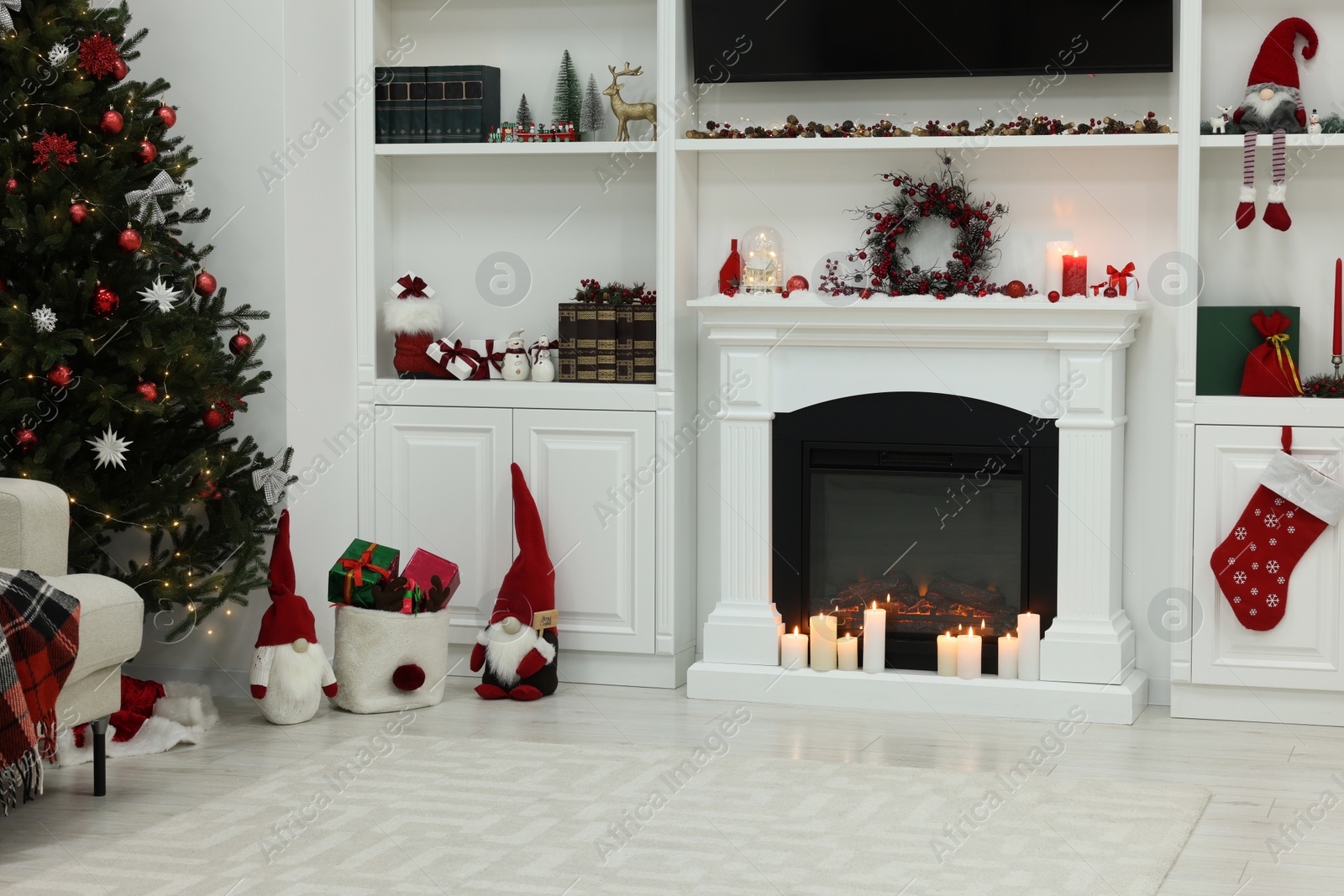 Photo of Cosy room with fireplace and burning candles. Christmas atmosphere