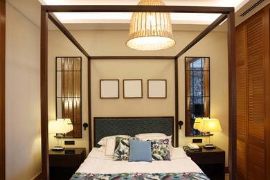 Large bed, lamps and pictures in comfortable hotel room