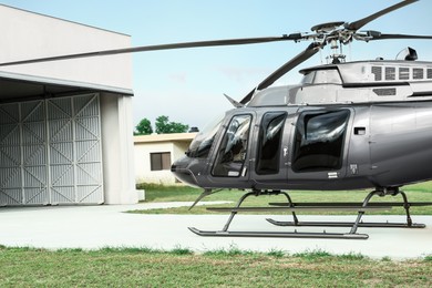 Photo of Beautiful helicopter on helipad in field near hangar