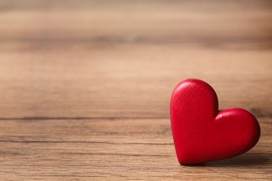 Red decorative heart on wooden table, space for text. Valentine's Day