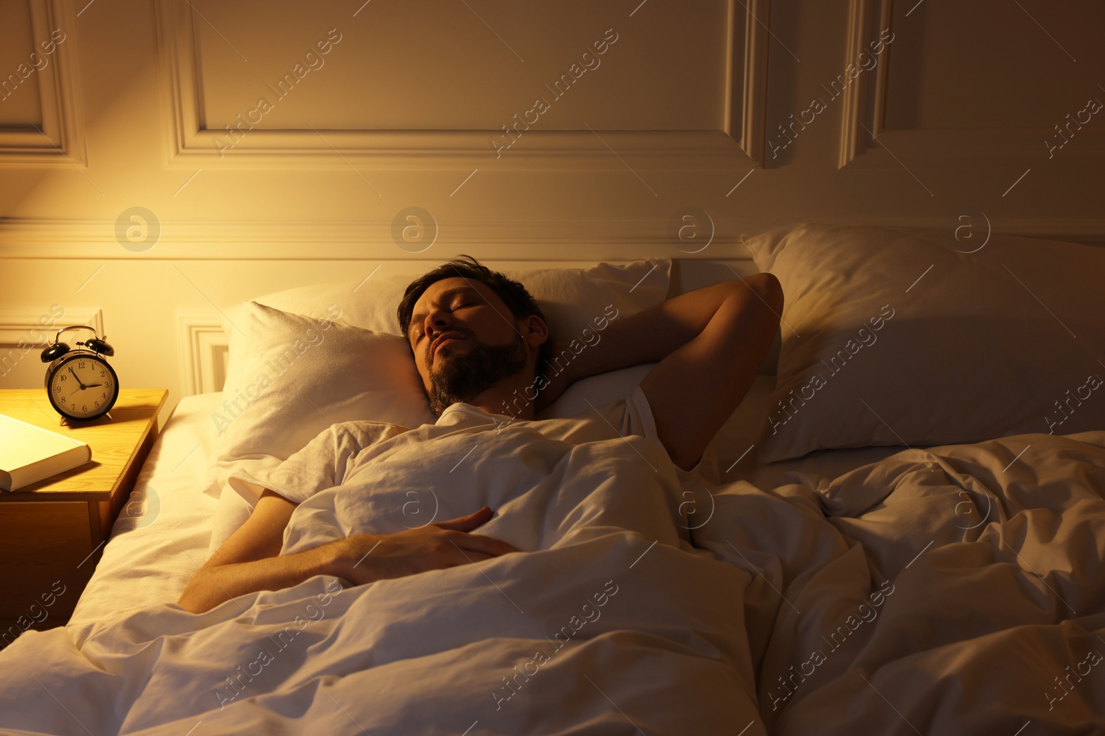 Photo of Handsome man sleeping in bed at night