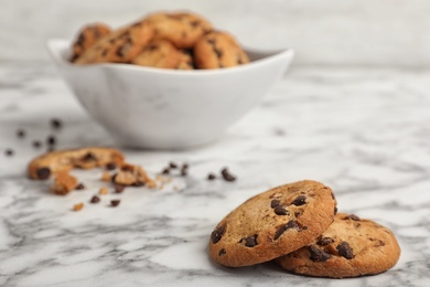 Photo of Tasty cookies with chocolate chips on marble table