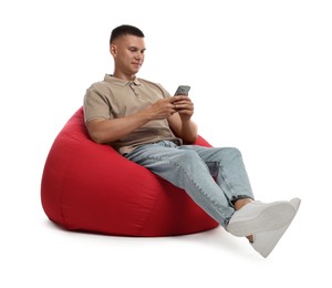 Photo of Handsome man with smartphone on red bean bag chair against white background