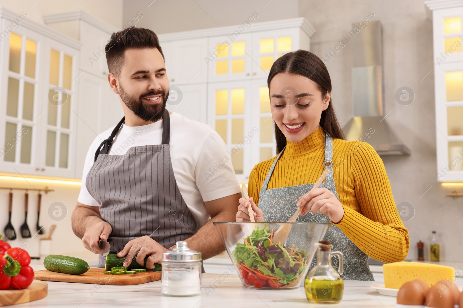 Photo of Lovely young couple cooking together in kitchen