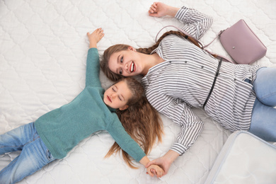 Photo of Mother and daughter testing mattress in store, top view