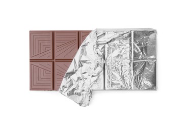 Photo of Delicious milk chocolate bar wrapped in foil isolated on white, top view