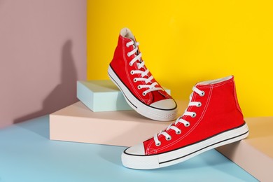 Photo of Pair of stylish sneakers on color background