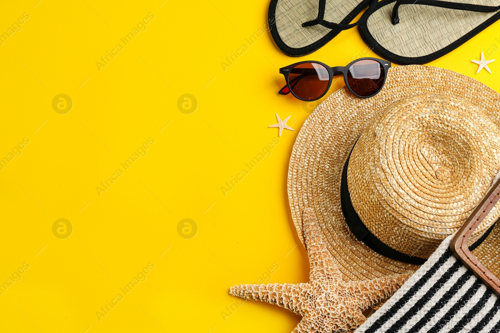 Photo of Flat lay composition with sunglasses and beach accessories on yellow background. Space for text