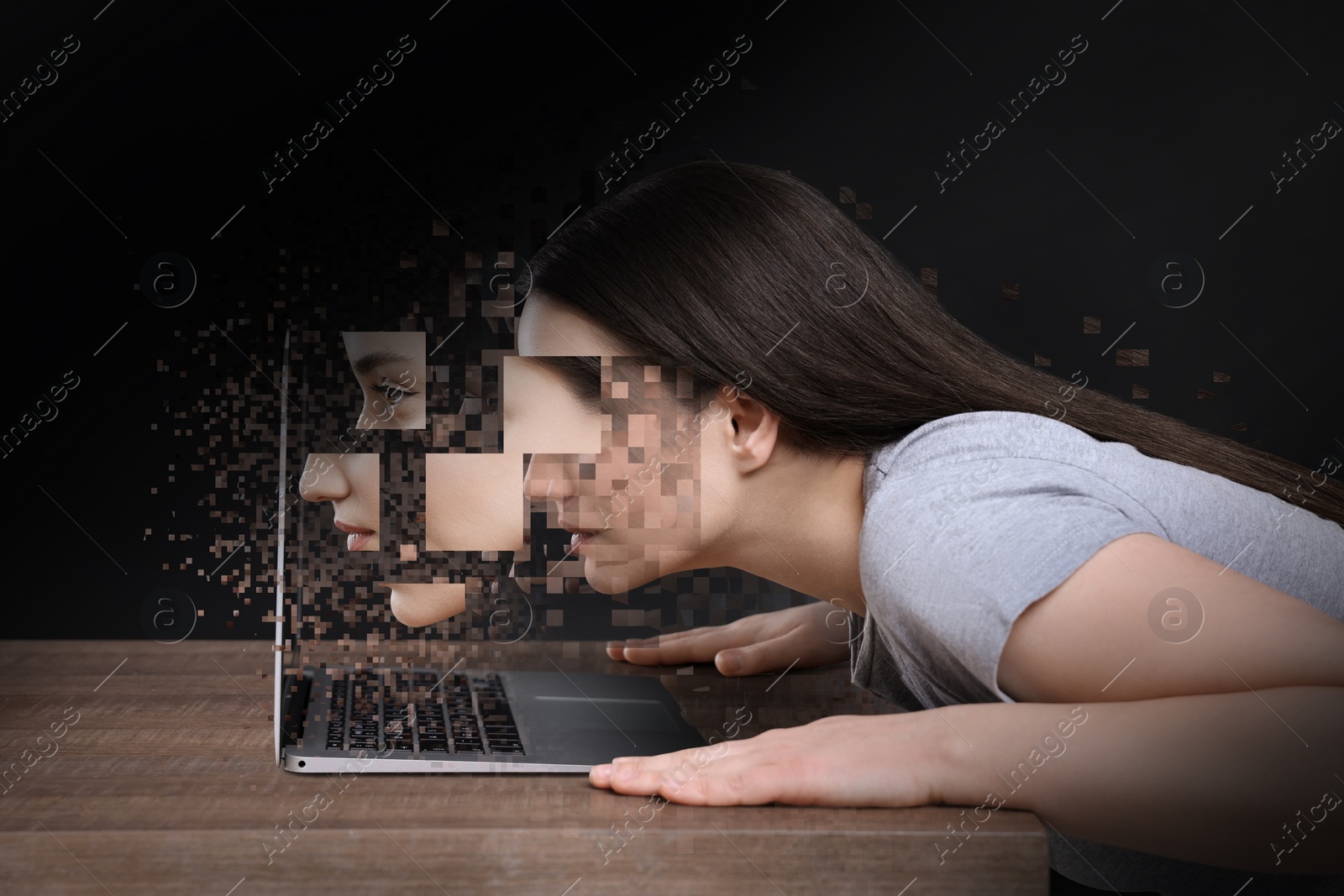 Image of Internet addiction. Young woman breaking up into pixels while staring at laptop