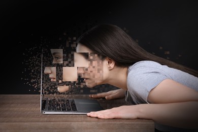 Image of Internet addiction. Young woman breaking up into pixels while staring at laptop