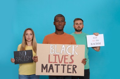 Group of people holding signs on light blue background. Racism concept