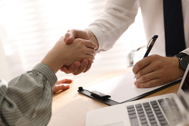 Business people shaking hands in office, closeup