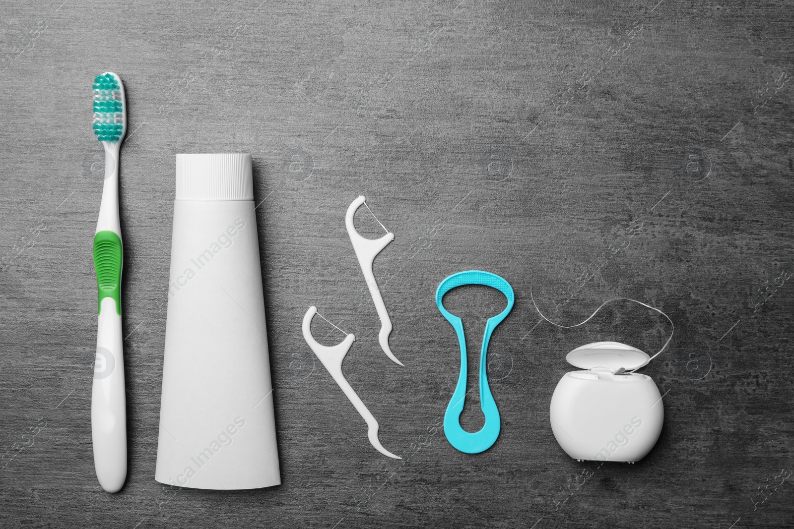 Photo of Flat lay composition with tongue cleaner and teeth care products on grey background