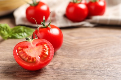 Photo of Fresh cherry tomatoes on wooden background. Space for text