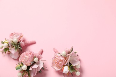 Photo of Stylish boutonnieres on pink background, flat lay. Space for text