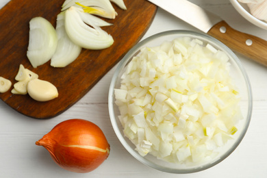 Photo of Flat lay composition with cut onion on white wooden table, flat lay