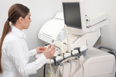 Professional sonographer using modern ultrasound machine in clinic