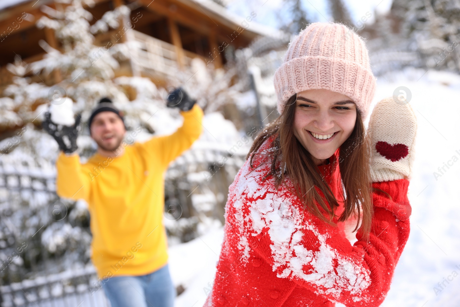 Photo of Happy couple playing snowballs outdoors. Winter vacation